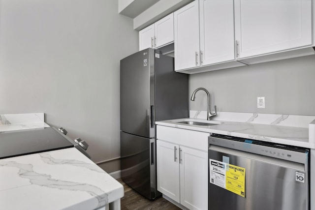 kitchen with white cabinetry, light stone countertops, appliances with stainless steel finishes, and dark hardwood / wood-style floors