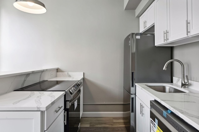 kitchen featuring white cabinets, light stone counters, dark hardwood / wood-style flooring, and stainless steel range with electric cooktop