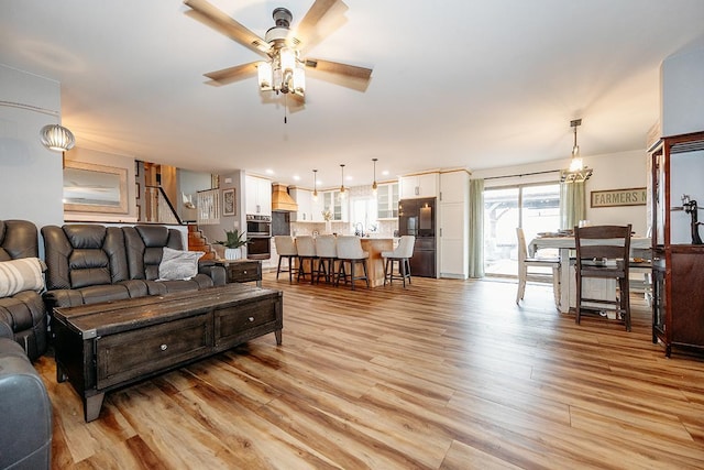 living room with light hardwood / wood-style floors and ceiling fan