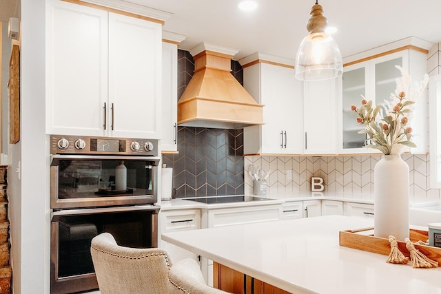 kitchen with premium range hood, double oven, tasteful backsplash, black electric stovetop, and white cabinets