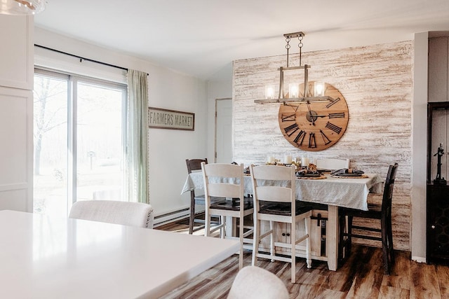 dining area featuring a baseboard radiator, dark wood-type flooring, a notable chandelier, and wooden walls