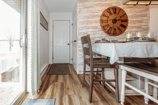 dining room featuring hardwood / wood-style floors and wooden walls