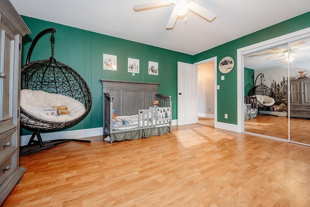 bedroom featuring hardwood / wood-style flooring, ceiling fan, and a closet