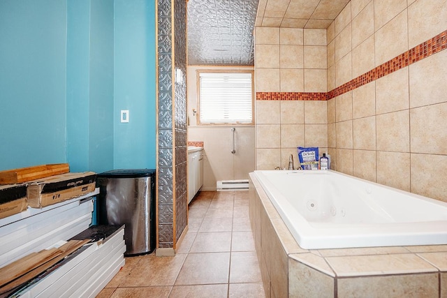 bathroom with a baseboard radiator, tile walls, tile patterned flooring, vanity, and a relaxing tiled tub