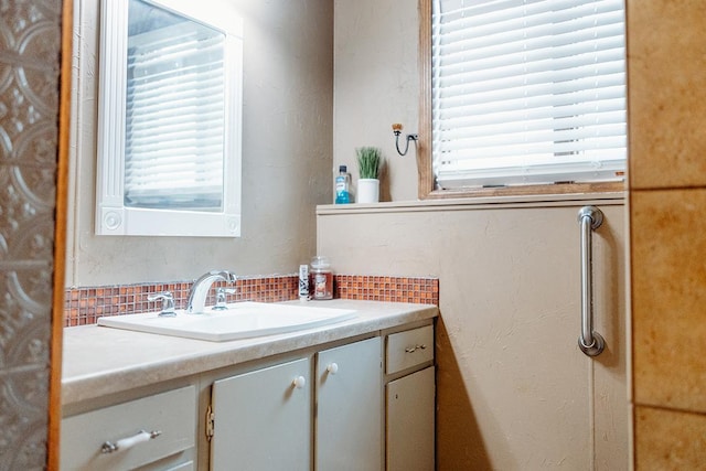 bathroom with tasteful backsplash and vanity