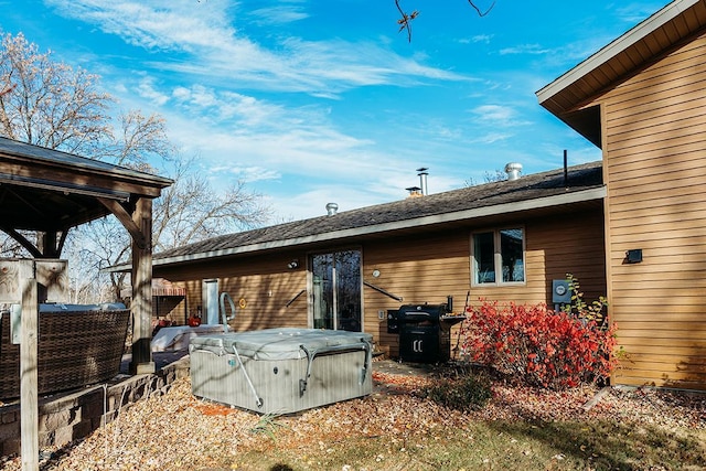 back of property with a hot tub