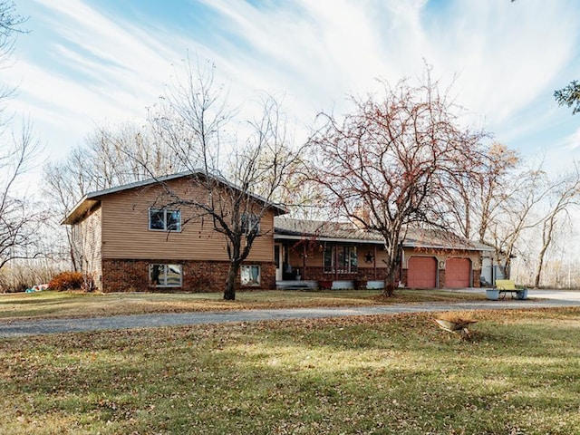 tri-level home featuring a garage and a front yard