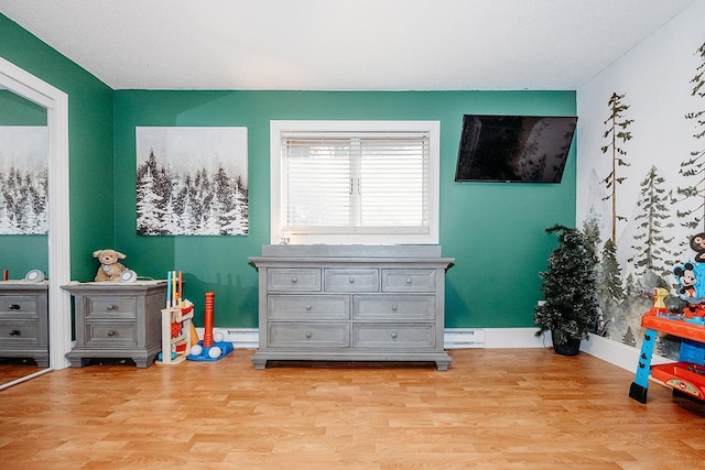 playroom with a baseboard radiator and light hardwood / wood-style floors