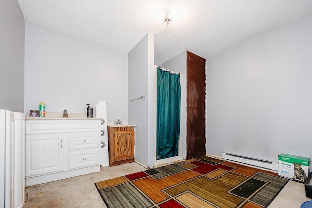 bathroom featuring sink, curtained shower, and baseboard heating