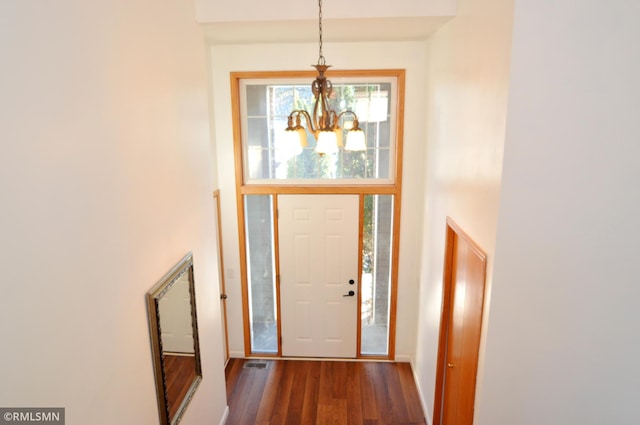 entryway featuring dark hardwood / wood-style flooring and an inviting chandelier