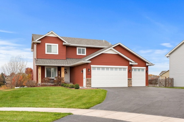 craftsman house with a front lawn and a garage