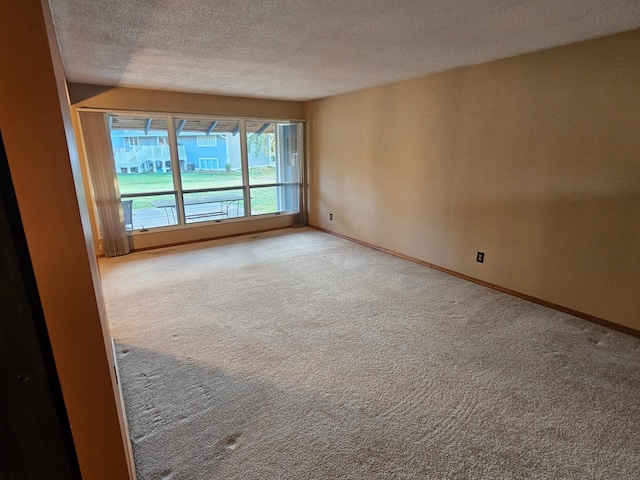 carpeted spare room featuring a textured ceiling