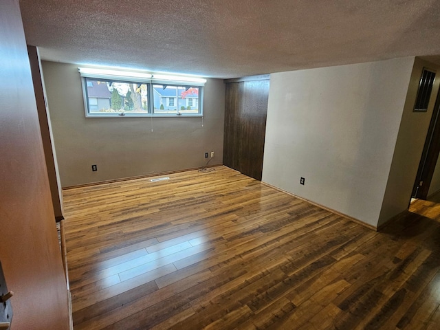 unfurnished room featuring hardwood / wood-style floors and a textured ceiling