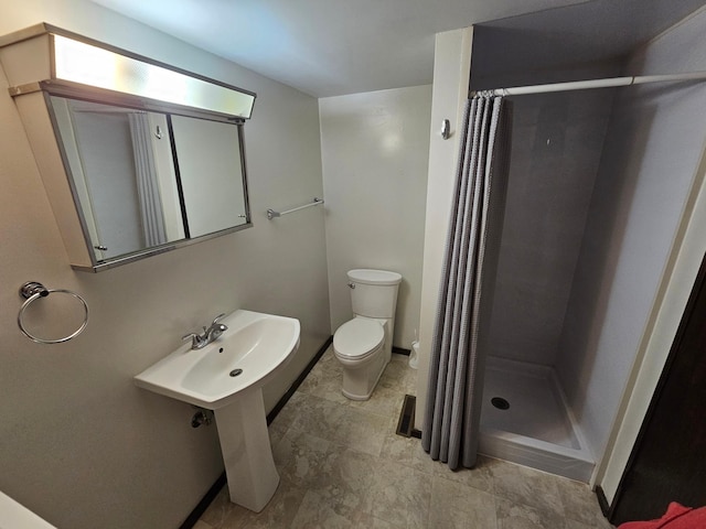 bathroom with toilet and a shower with shower curtain