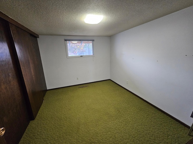 unfurnished room featuring a textured ceiling, carpet, and golf simulator