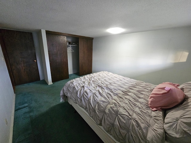 bedroom featuring a closet, a textured ceiling, and dark carpet