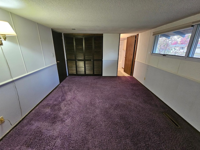 interior space with carpet flooring and a textured ceiling