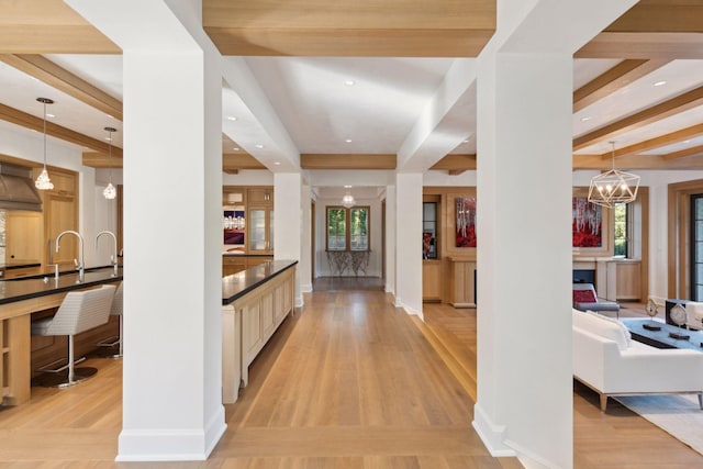 interior space featuring a healthy amount of sunlight, light hardwood / wood-style flooring, and a chandelier