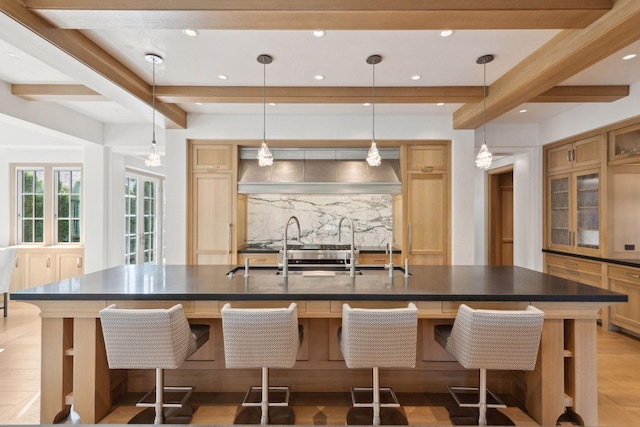 kitchen with beam ceiling, a large island, and a breakfast bar area