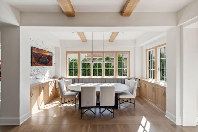 dining space with light hardwood / wood-style floors and beam ceiling