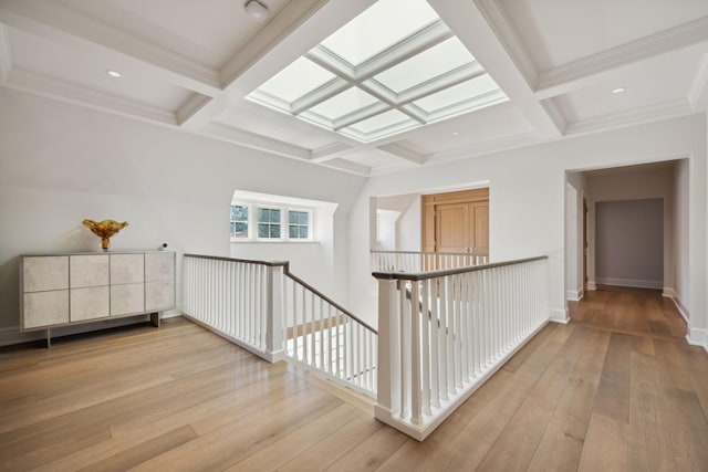 hallway featuring light hardwood / wood-style flooring, beamed ceiling, and coffered ceiling