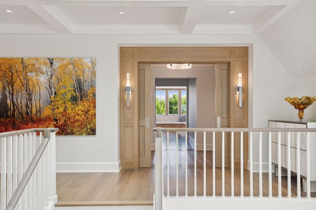 corridor with light hardwood / wood-style floors, crown molding, beamed ceiling, and coffered ceiling