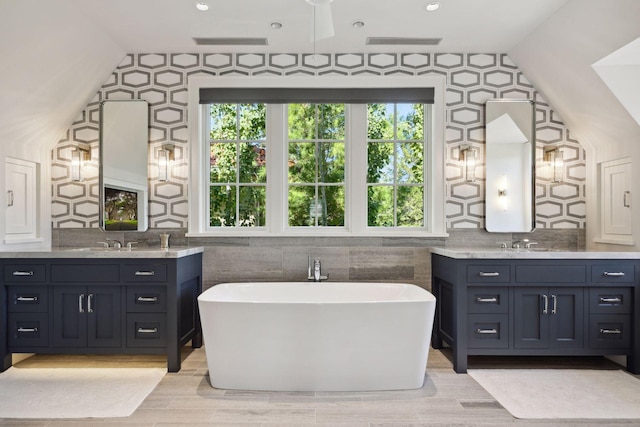 bathroom with vanity, a tub, and hardwood / wood-style floors