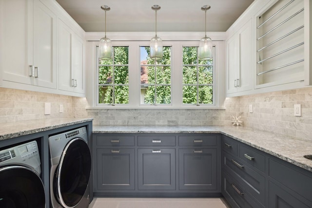 washroom with washer and clothes dryer and cabinets