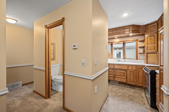 bathroom with vanity, a textured ceiling, and toilet