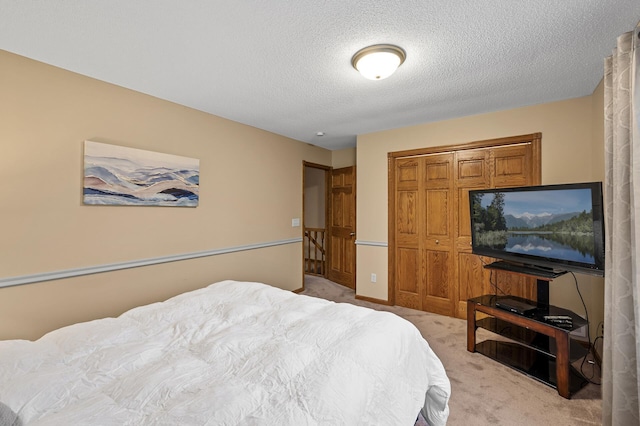 bedroom with light carpet, a closet, and a textured ceiling