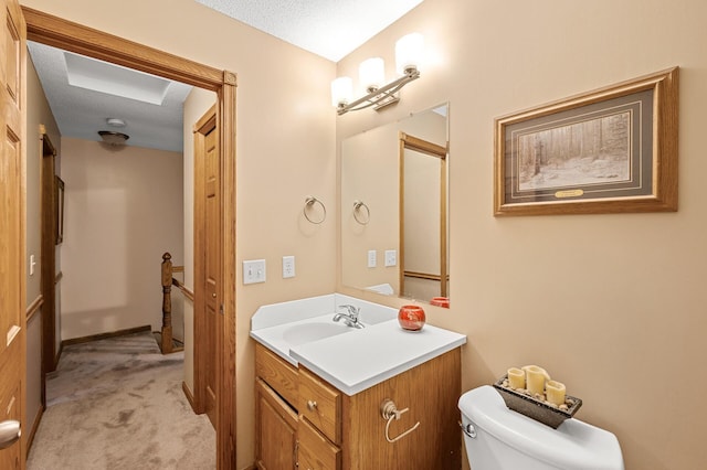 bathroom with toilet, a textured ceiling, and vanity