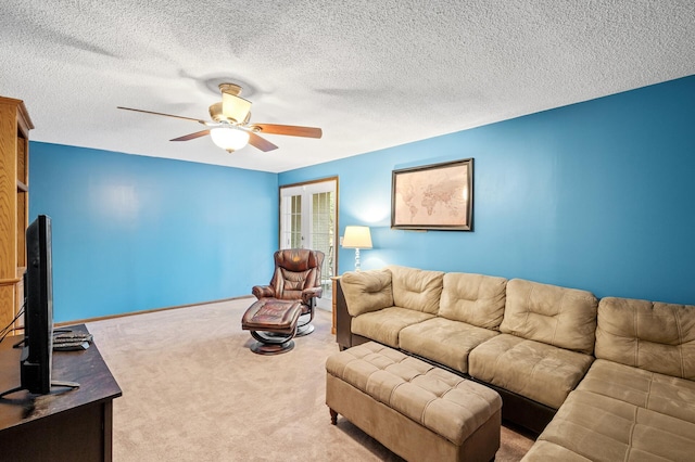 carpeted living room featuring ceiling fan and a textured ceiling