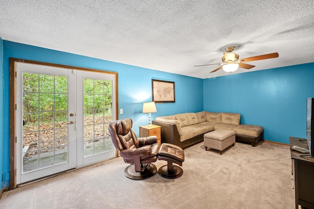 living room featuring light carpet, a textured ceiling, and ceiling fan