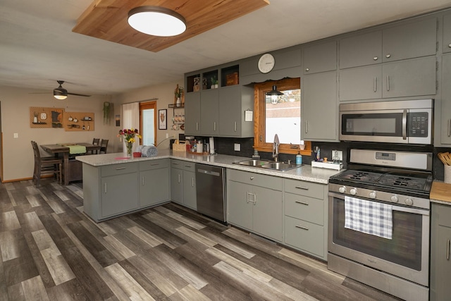 kitchen featuring sink, kitchen peninsula, ceiling fan, stainless steel appliances, and dark hardwood / wood-style floors