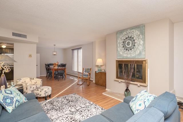 317 6th Ave SW Unit 501, Rochester, MN 55902 - living area featuring light wood-style flooring, a baseboard heating unit, and a textured ceiling