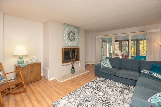317 6th Ave SW Unit 501, Rochester, MN 55902 - living room with wood finished floors, a textured ceiling, and a baseboard radiator