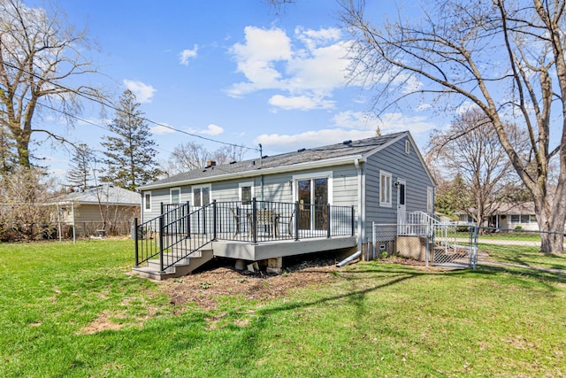 back of house featuring a wooden deck, a gate, roof with shingles, a lawn, and fence