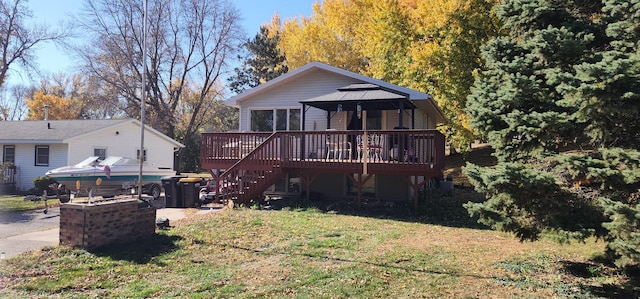 back of house with a deck and a lawn