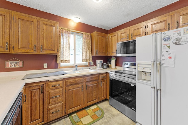 kitchen featuring sink, stainless steel appliances, and a textured ceiling