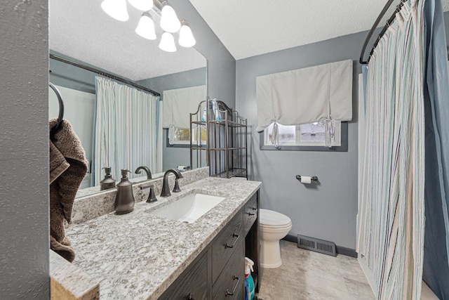 bathroom with vanity, a textured ceiling, and toilet