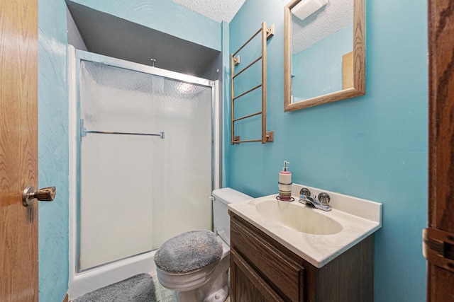 bathroom featuring a shower with door, toilet, a textured ceiling, and vanity