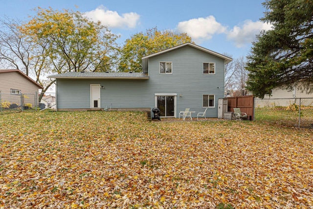 rear view of property featuring a lawn