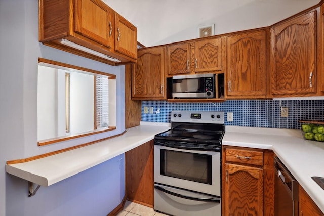 kitchen featuring tasteful backsplash, stainless steel appliances, and light tile patterned floors