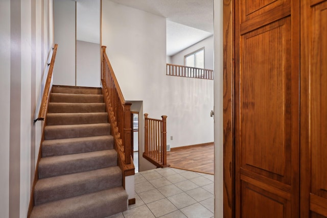 staircase with hardwood / wood-style flooring and high vaulted ceiling