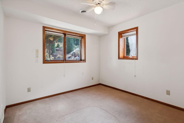 spare room featuring a textured ceiling, ceiling fan, and carpet floors