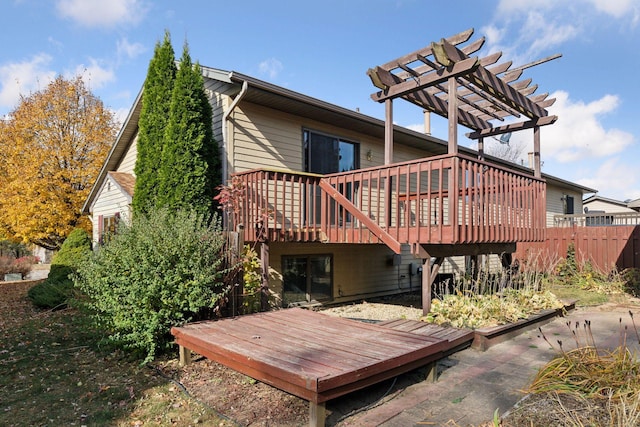 back of house with a wooden deck and a pergola