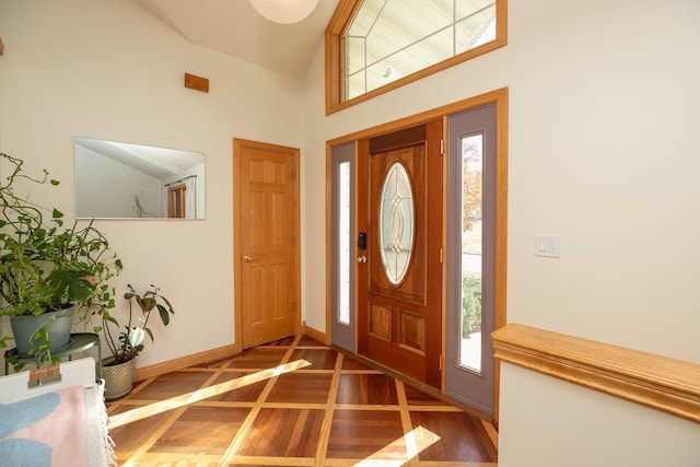 foyer featuring parquet floors, a healthy amount of sunlight, and a high ceiling