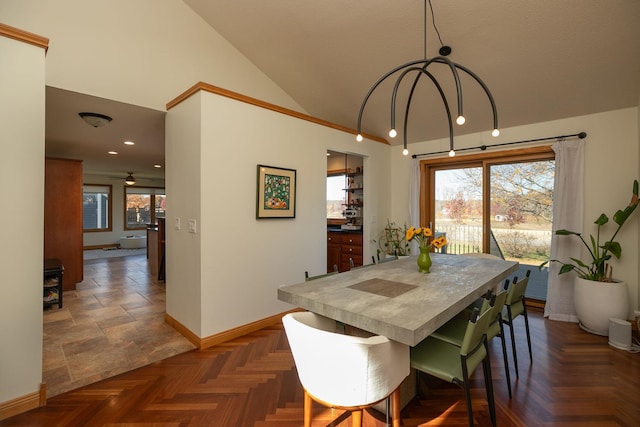 dining space featuring vaulted ceiling and dark parquet flooring