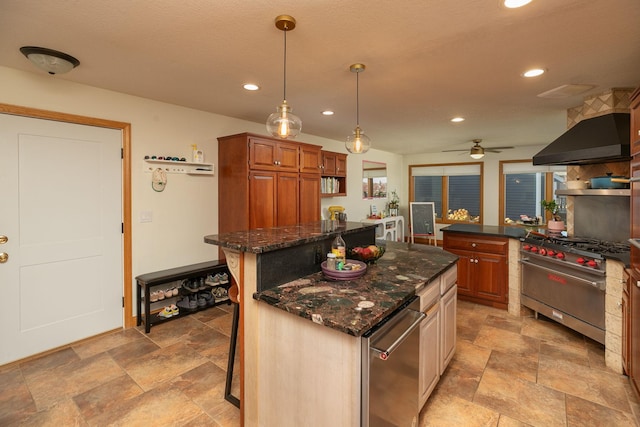 kitchen featuring ceiling fan, a kitchen bar, dark stone countertops, stainless steel appliances, and a center island