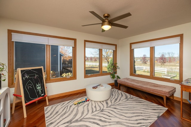 sitting room with a textured ceiling, ceiling fan, and dark hardwood / wood-style flooring